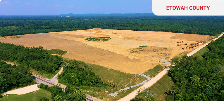 Aerial view of a cleared land in Etowah County with trees and machinery