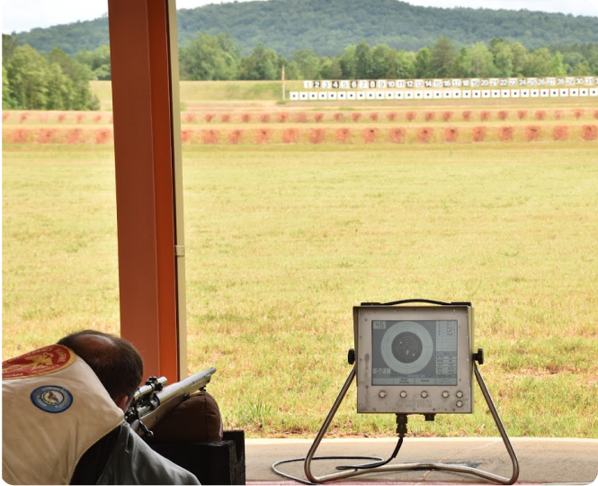 A shooter preparing to aim at a distant target range setup
