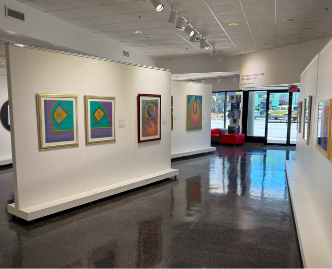 Art gallery interior showing colorful framed paintings on display