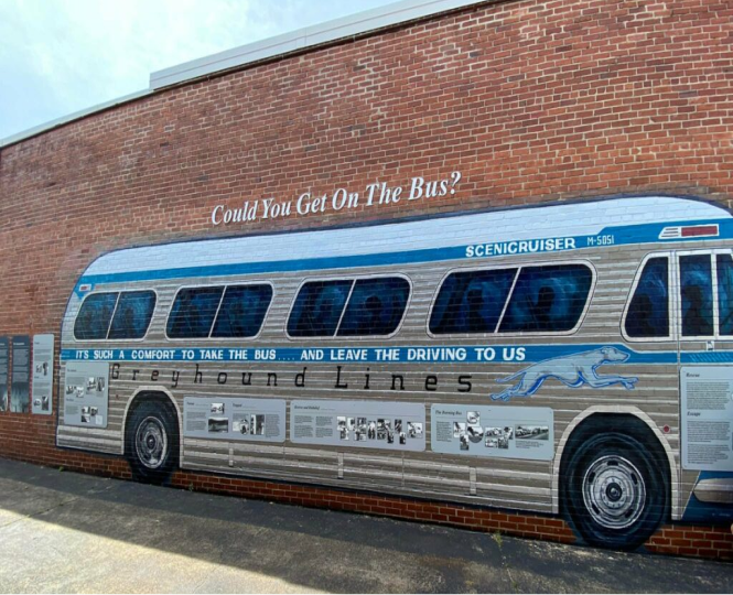 Mural of a vintage Greyhound bus with historical text